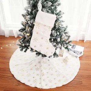 Vue détaillée de la jupe de sapin de Noël en peluche blanche avec des flocons dorés.