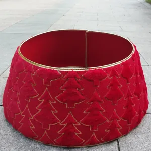 Détail de col de sapin de Noël en peluche rouge, motifs d'arbres et bordure dorée élégante.