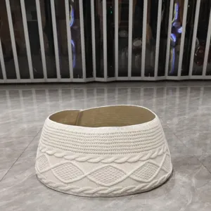 Detailopname van een witte gebreide kerstboomrok met klassiek kabel- en ruitpatroon.