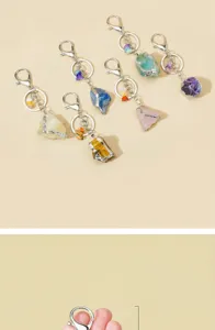 Detail view of natural rough crystal stone keychains with silver edges and secure clasps.