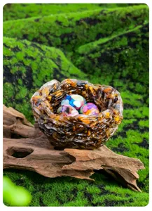 Resin bird nest ornament detail, colorful stone eggs display, decorative home centerpiece.