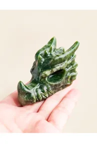 Close-up detail of a hand-carved green crystal dragon head sculpture, natural gemstone texture.