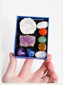 Vue détaillée du set de cristaux naturels avec pierres de chakra et grappes dans une boîte.