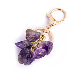 Natuurlijke amethist ruwe steen sleutelhanger met gouden metalen sluiting en tas hanger.