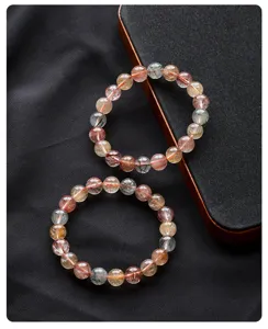 Natural multi-color rutilated quartz crystal gemstone bracelet detail view showing colorful threads.
