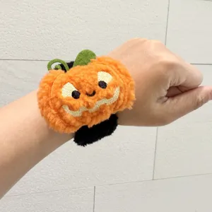Nahaufnahme des niedlichen Halloween Plüsch Kürbis Schnapparmbands mit weicher Stickerei.