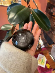 Natural gold obsidian sphere detail shot, crystal ball gemstone feng shui decor for home office.