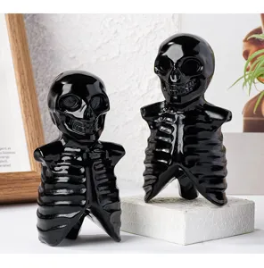 Detailed view of black obsidian crystal skeleton skull sculpture for Halloween home decor.