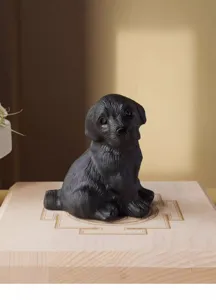 Primo piano della statuetta di cane in ossidiana nera scolpita con finitura liscia decoro.