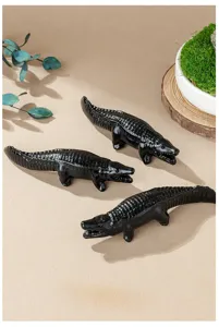Nahaufnahme der schwarzen Obsidian Kristall geschnitzten Alligator Figur als Tischdekoration.