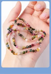 Primo piano del bracciale multi-giro in pietre irregolari di tormalina colorata.