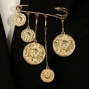 Nahaufnahme einer vintage goldenen Sonnengesicht-Brosche mit Metallquasten-Detail