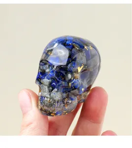 Close-up detail shot of crystal stone resin skull decor with blue chips and gold foil.
