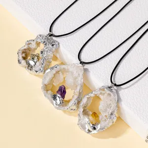 Natural crystal geode pendant necklace with electroplated silver edge and black cord.