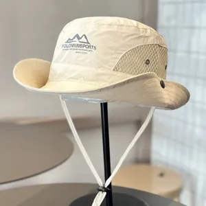 Beige outdoor bucket hat with breathable mesh panels, chin strap, and stylish front print.