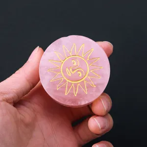 Natural rose quartz crystal disc with gold laser engraved sun pattern detail shot display
