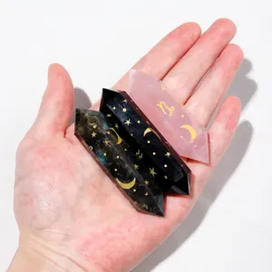 Detailed view of natural crystal wands featuring laser-engraved gold stars and zodiac symbols.