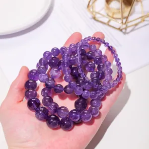 Natural amethyst beaded bracelet detail view showing polished purple crystal gemstone jewelry stones.