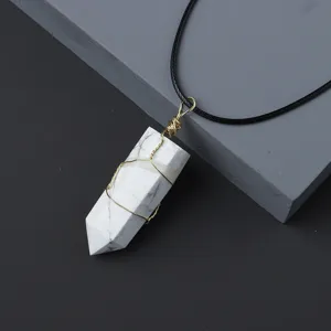Detail view of natural crystal hexagonal column pendant wrapped in gold wire with black cord.
