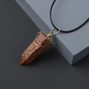 Natural crystal hexagonal pillar pendant with gold wire wrapping and black cord necklace detail.