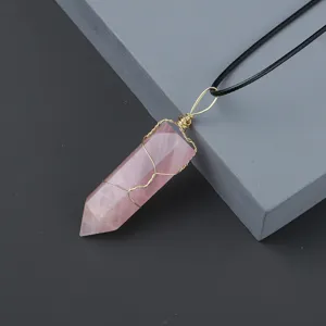 Natural rose quartz crystal hexagonal prism pendant necklace detail with handmade wire wrap.