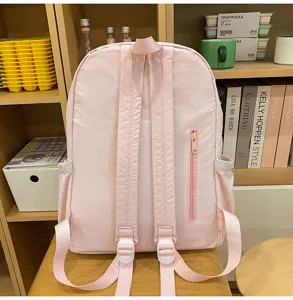 Detailed view of the pink casual campus backpack showing the back straps and zipper pocket.
