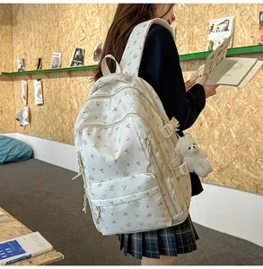 Detail view of a fresh floral backpack featuring a lovely small bear pendant and multi pockets.