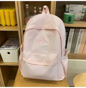 Detailed shot of a casual pink campus backpack, showcasing front pocket design and soft fabric texture.