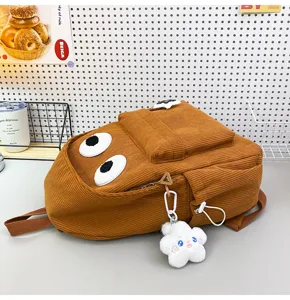 Brown corduroy backpack detail with cute big eyes design and cloud pendant for daily casual wear.