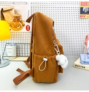 Brown corduroy backpack with side pockets and cute fluffy cloud charm for daily use.