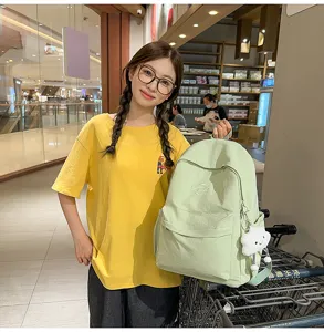 Detail view of light green casual canvas backpack with cute cloud pendant, perfect for students.