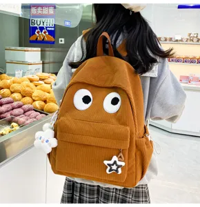 Cute brown corduroy backpack detail shot featuring funny big eyes and sweet star pendants.