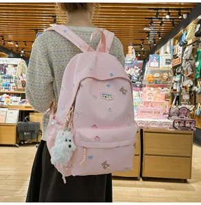Cute pink school backpack for girls with bear print, large capacity and plush dog pendant.