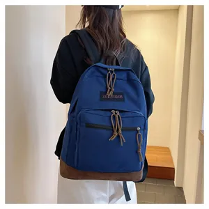 Casual canvas backpack with contrast bottom, front zip pocket, stylish school bag for daily use.