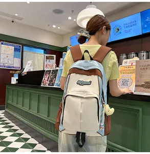 Casual colorblock school backpack for women, stylish student daypack with cute pendant detail.