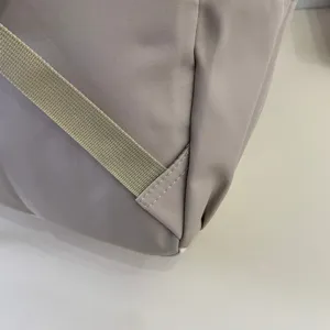Close up of casual backpack strap and stitching detail in beige color, fine craftsmanship.
