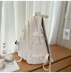 Detailed side view of the beige canvas backpack showing multi-pocket design and buckles.