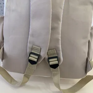 Close-up detail view of khaki casual student backpack featuring adjustable shoulder straps.