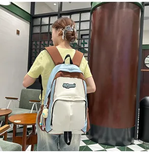 Detail shot of stylish multi-color student backpack with cute pendant for daily school use.