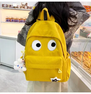 Cute yellow corduroy backpack for women, stylish student school bag with big eyes and lovely charms.