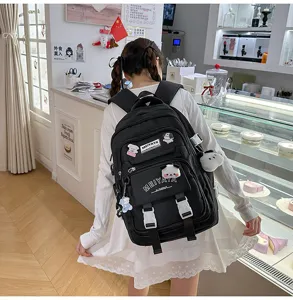 Large capacity black student backpack with cute plush pendants, casual travel school bag.