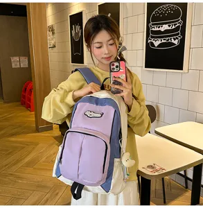 Detailed view of the stylish color-block student backpack in purple and white, perfect for daily use.