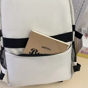 Detailed view of white student school backpack with black straps and large capacity storage.
