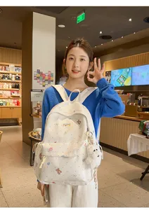Detailed view of cute bear print canvas backpack with plush pendant for daily use.