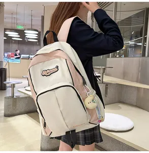 Stylish campus backpack for women, colorblock design, durable canvas school bag with charm.