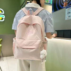 Casual pink school backpack for women, lightweight nylon travel bookbag with cute charm.