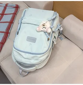 Light blue large capacity school backpack detail featuring cute bow embroidery and bear pendant.
