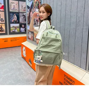 Casual minimalist nylon backpack with cute bear pendant, lightweight commuter school bag.