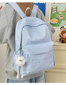 Light blue star print canvas backpack with cute fluffy charm for daily school and travel use.