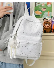 White star print casual backpack detail view with front pocket and plush pendant accessory.